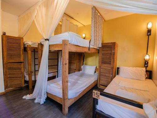 Twee stapelbedden in een kamer met houten vloeren. bij The Slow Leopard in Dar es Salaam