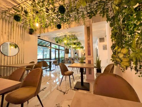 a restaurant with tables and chairs and plants on the walls at Bigala Ocnele Mari in Ocnele Mari