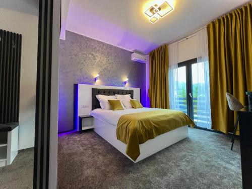 a purple bedroom with a bed and a window at Bigala Ocnele Mari in Ocnele Mari