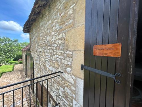 a wooden door with a sign on the side of a building at Demeure du Vallon - Chambres d'Hôtes de Charme in Azerat