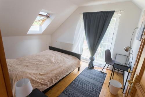 a bedroom with a bed and a window and a desk at Hi-Bp Garden city Batsanyi Apartment 3 Rooms, Apartment upstairs near the city train with FREE PARKING in Budapest
