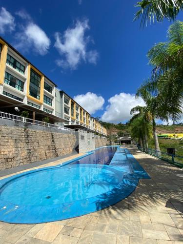 une grande piscine bleue à côté d'un bâtiment dans l'établissement AP alto da serra Villas 104A, à Bananeiras