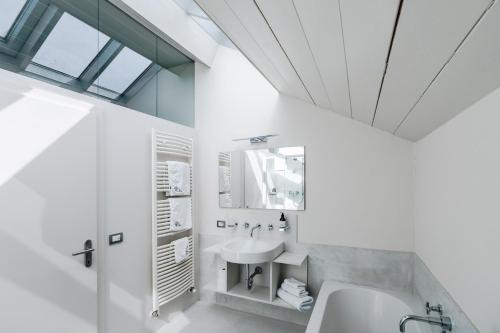 a white bathroom with a sink and a mirror at Picenin 61 Lodging in La Villa