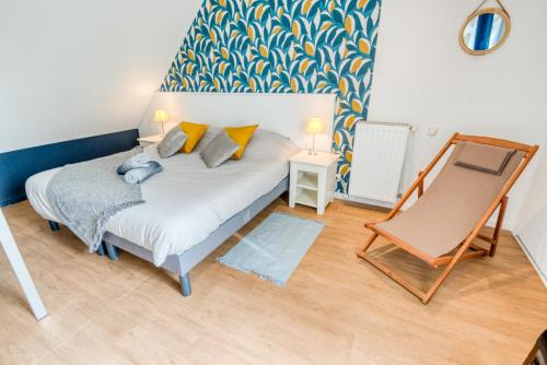 une petite chambre avec un lit et une chaise dans l'établissement Grand duplex bord de plage avec Terrasse par Groom, à Guidel