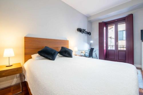 Un dormitorio con una gran cama blanca y una ventana en Chueca Gran Via Recoletos Libertad 24 8 en Madrid