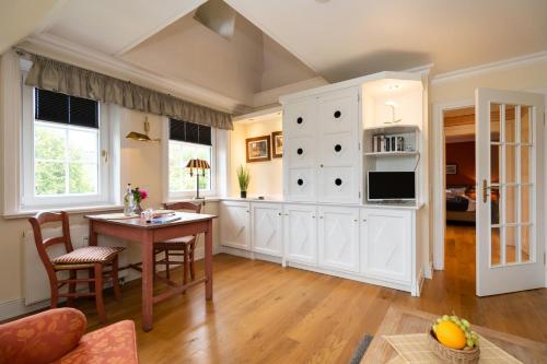 a kitchen with a table and a dining room at Hotel Parkresidenz Christian VIII in Archsum