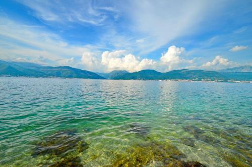 a view of a large body of water with mountains at Sun Ray Apartments in Tivat