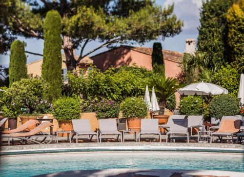 a swimming pool with lounge chairs and umbrellas at Hotel Byblos Saint-Tropez in Saint-Tropez