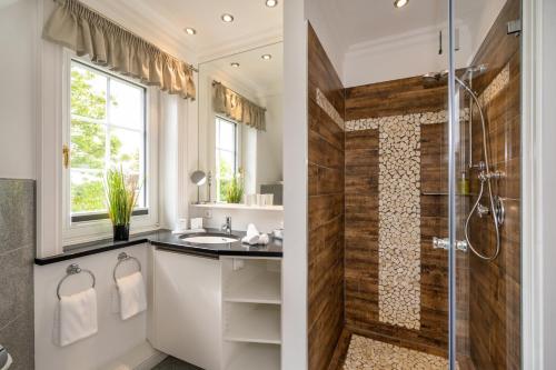 a bathroom with a shower and a sink at Hotel Parkresidenz Christian VIII in Archsum