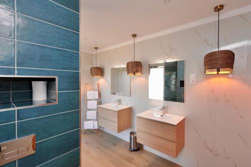 a bathroom with two sinks and a mirror at Domaine Pozzo di Mastri in Figari