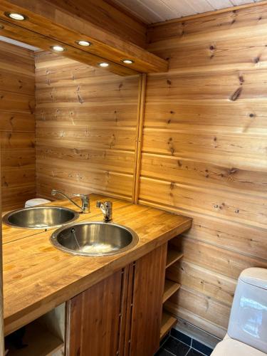 ein Badezimmer mit zwei Waschbecken auf einer Holztheke in der Unterkunft Villa Tourula in Jyväskylä