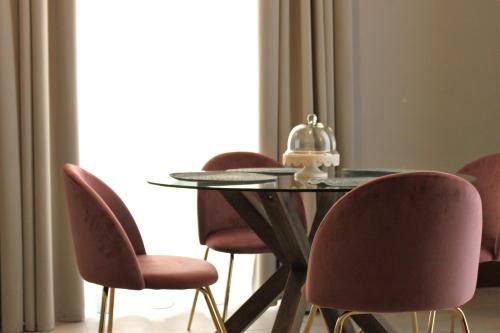 a dining room table with chairs and a glass table with a helmet on it at Palazzo sul Corso-Charming Appartaments in Brindisi