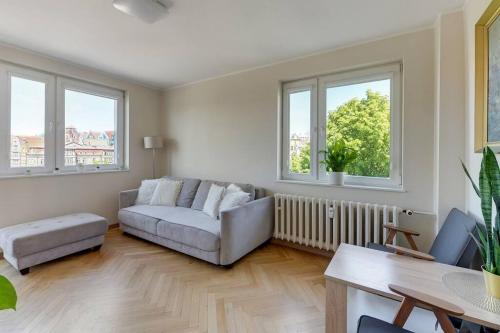 a living room with a couch and two windows at Motława 1 by Grand Apartments in Gdańsk