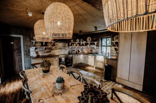 a kitchen with a wooden table and chairs and chandeliers at Runa Farm in Barnard Castle