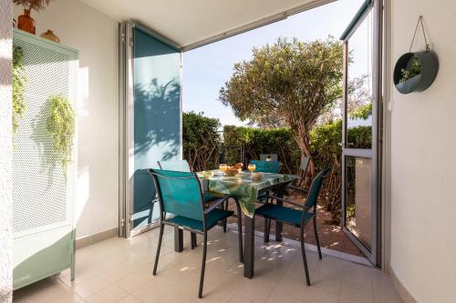 une salle à manger avec une table et des chaises sur un patio dans l'établissement The Bohemia by POM, terrasse, parking, au Cap d'Agde