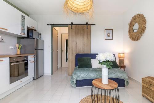 Il comprend un salon avec un lit bleu et une cuisine. dans l'établissement The Bohemia by POM, terrasse, parking, au Cap d'Agde