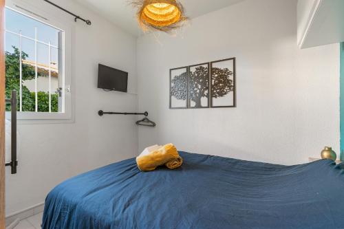 une chambre avec un lit bleu et une fenêtre dans l'établissement The Bohemia by POM, terrasse, parking, au Cap d'Agde