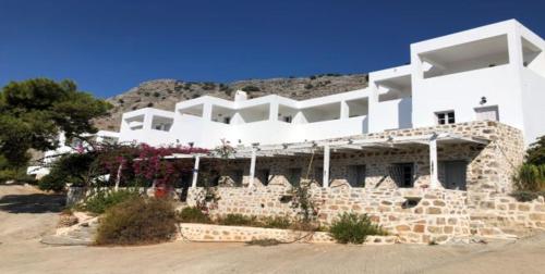 a large white building with flowers in front of it at Karpathios Studios Pefkos in Pefki Rhodes