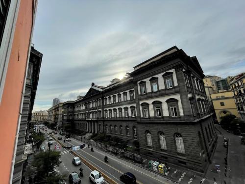 un grand bâtiment dans une rue de la ville avec des voitures dans l'établissement Cosy Domy Apartments, à Naples