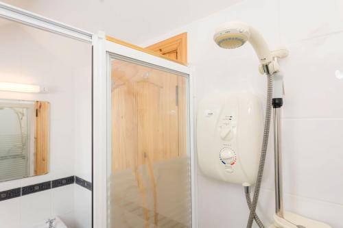 La salle de bains est pourvue d'une douche avec un pommeau de douche. dans l'établissement Kilkee Townhouse, à Kilkee