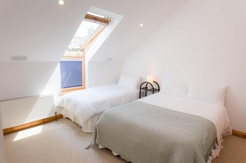 a bedroom with two beds and a window at Kilkee Townhouse in Kilkee