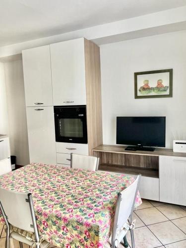 a room with a table with chairs and a television at Alloggio MAIA centro Biella in Biella