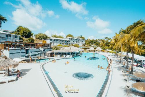 a view of the black drupal resort pool at Appart 'Caraibe Résidence MARINE HOTEL in Le Diamant
