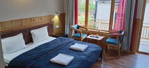 - une chambre avec un lit et 2 serviettes dans l'établissement Chandan Guest House, à Leh