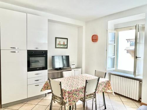 a dining room with a table and chairs and a television at Alloggio MAIA centro Biella in Biella