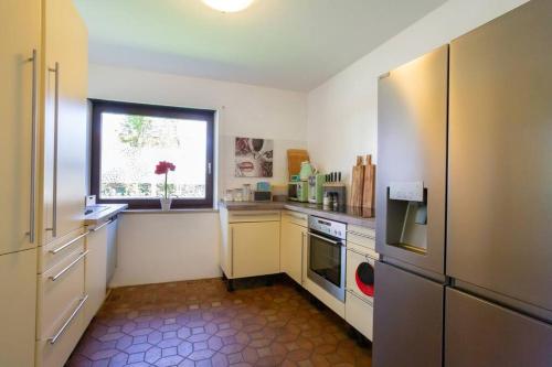 a kitchen with a refrigerator and a window at Villa am Wehr in Allersberg