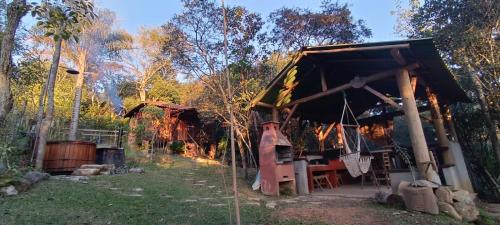 Vila do Mago في إتامونتي: كابينة في وسط غابة فيها طاولة وكراسي