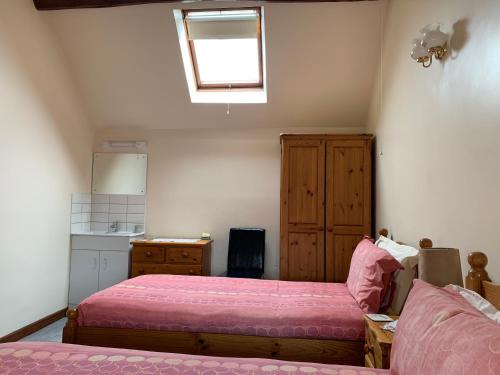 a bedroom with a bed and a couch and a window at Irelands Farm Cottages in Birmingham
