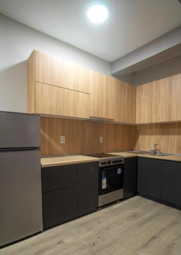 une cuisine vide avec des placards en bois et une cuisinière dans l'établissement Apartmani 18-ka, à Gevgelija