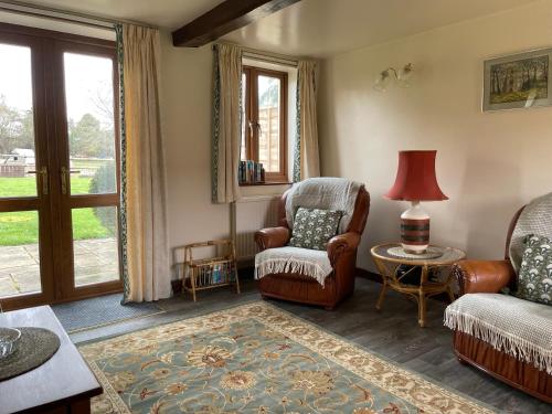 a living room with a couch and a chair and a table at Irelands Farm Cottages in Birmingham