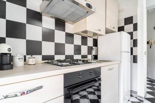 a kitchen with a black and white checkered wall at Chess House in Azzano Mella