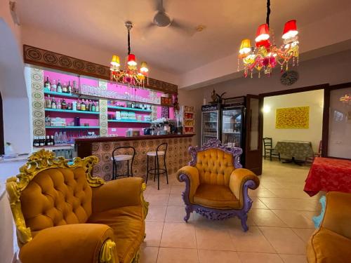 a bar with two yellow chairs and a counter at Hotel Miramare Garzia in Marinella di Selinunte