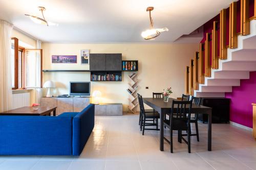 ein Wohnzimmer mit einem blauen Sofa und einem Tisch in der Unterkunft Casa Vittoria in Potenza Picena
