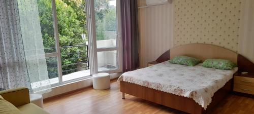 a bedroom with a bed and a large window at Lily Pearls Inn in K'obulet'i