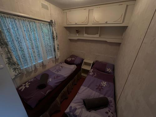 a small room with two beds and a window at Autocamp Free Star - Mobilheimy in Strachotín