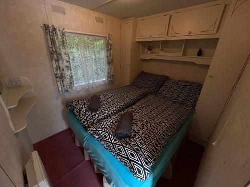 a bed in a small room with shoes on it at Autocamp Free Star - Mobilheimy in Strachotín