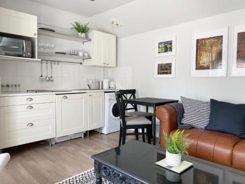 a kitchen and living room with a couch and a table at The Wren in Blackfordby