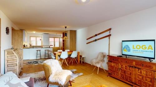 a living room with a television on a wooden dresser at Guardaval 15 in Surlej