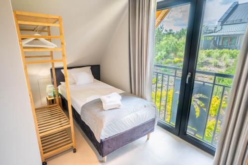 sypialnia z łóżkiem piętrowym i drabiną w obiekcie Palmowe Wzgórze Skoszewo - Domek Górny w mieście Skoszewo