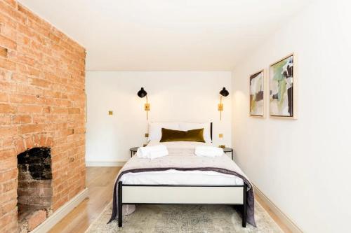 a bedroom with a bed and a brick wall at Pass the Keys Central Stratford upon Avon Super Stylish 1Bed in Stratford-upon-Avon