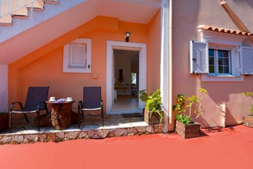 a house with two chairs and a table on a patio at Maria in Ágios Matthaíos