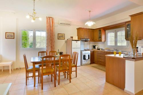 a kitchen and dining room with a table and chairs at Maria in Ágios Matthaíos