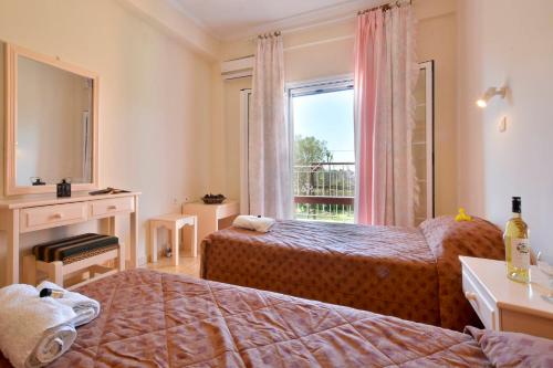 Ágios MatthaíosにあるMariaのベッド2台と窓が備わるホテルルームです。