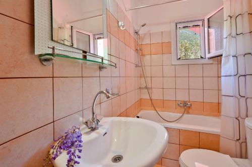 Ágios MatthaíosにあるMariaのバスルーム(洗面台、トイレ、鏡付)