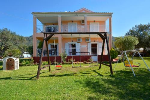 a house with a playground in front of it at Maria in Ágios Matthaíos