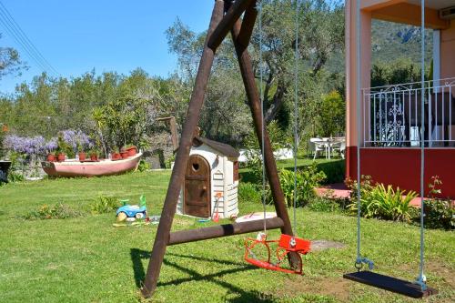 a playground in a yard with a dog house at Maria in Ágios Matthaíos